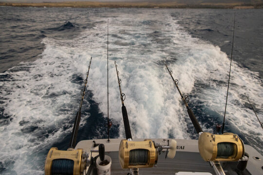 Fishing pole, rod and reel on an ocean fish trip during sunrise. 