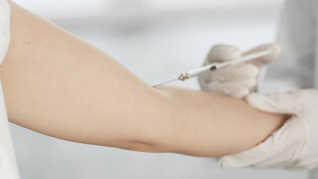 腕にワクチンの注射を受ける女性