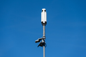 Obraz premium Mobile technology communication cell tower against a sunny blue sky, narrow metal monopole and small white panel antenna 