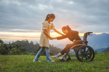 Happy young mother in wheelchair with care helper  daughter in spring nature at sunset.
