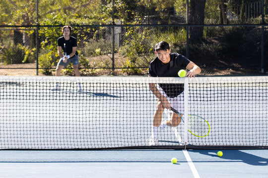Male Tennis Player in Action on Outdoor Court During Sunny Match