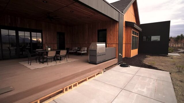 Panning reveal of a backyard patio deck of a luxury country cottage