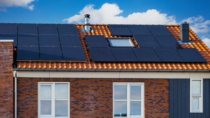 Newly build houses with black solar panels to the roof against a sunny sky, Close up of new...