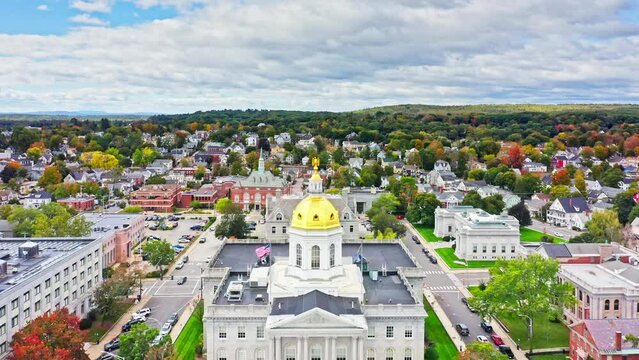 Aerial revealing shot of Concord, NH with slow camera pull back from the New Hampshire State House golden dome. The capitol houses the New Hampshire General Court, Governor, and Executive Council.