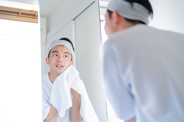 タオルで顔を拭く男性
