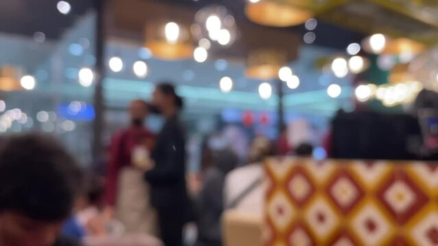 Blurred image inside a cafe, waiters serving visitors. Out of focus