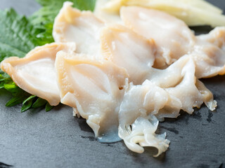 Whelk sashimi on a stone plate