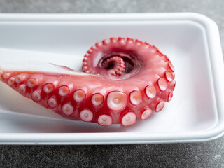 Boiled octopus legs in a disposable container