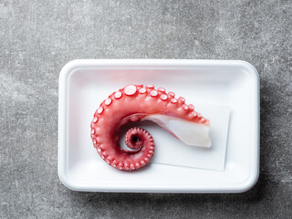 Boiled octopus legs in a disposable container © mnimage