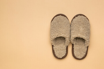 Homemade woolen slippers on a beige background.