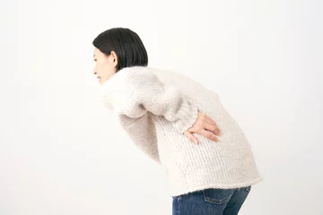Fotobehang 腰痛のミドルエイジの女性　白背景 © siro46