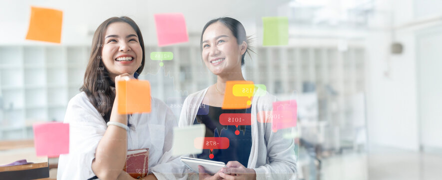 Creative business woman brainstorming using sticky notes on glass wall in office. - Powered by Adobe