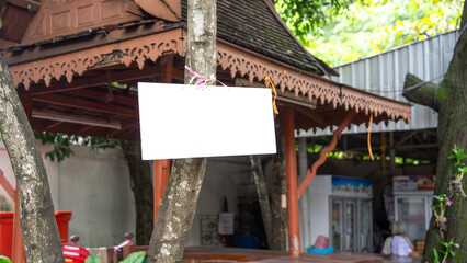 Hanging publicity signs tied to trees. Shop pavilion area that has people coming to use the service...