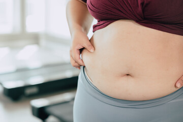 closeup women waist with thick fat tummy girl abdomen lady plus size big belly. - obrazy, fototapety, plakaty