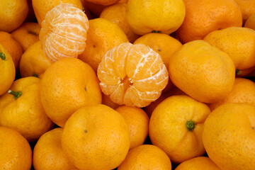 Unpeeled and peeled fresh ripe tangerines close up