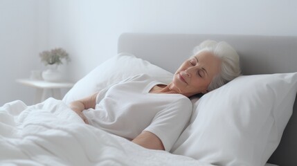 Senior woman sleeps in a white bed at home