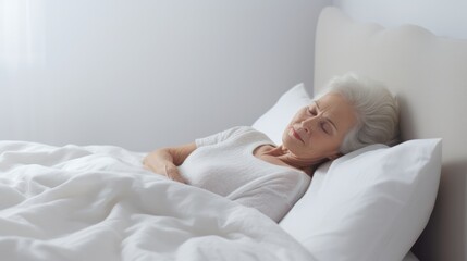 Obraz na płótnie Canvas Senior woman sleeps in a white bed at home