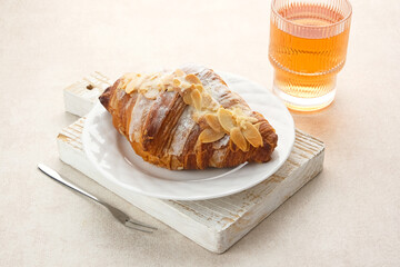 Almond Croissant with sprinkling icing sugar on white plate 
