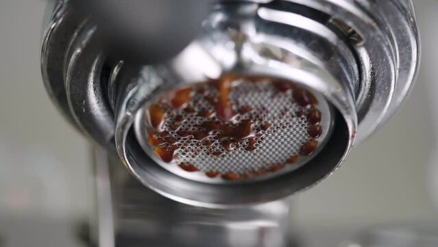 Slow motion closeup espresso extraction from bottomless portafilter