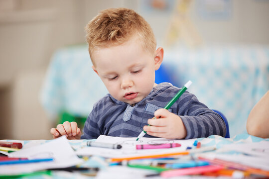 Face, kid and pencil for drawing in classroom for learning, education and development of motor skills. Little boy, student or learner with coloring activity for growth, future or milestone in daycare