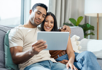 Happy couple, tablet and watching on sofa for online streaming, entertainment or social media at home. Man and woman smile and sitting in living room for technology, connection or networking at house