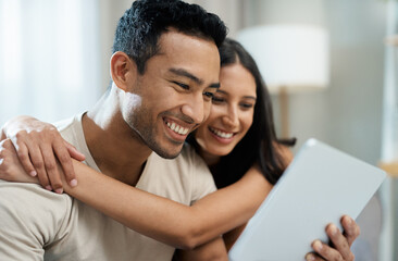 Obraz premium Hug, happy and couple with tablet on sofa relax with social media, movies or streaming film at home. Love, smile and people in living room with digital, search or app for show, video or communication