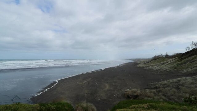 Muriwai Beach with big sea waves in bad weather: A Storm at New Zealand North Island Coast
