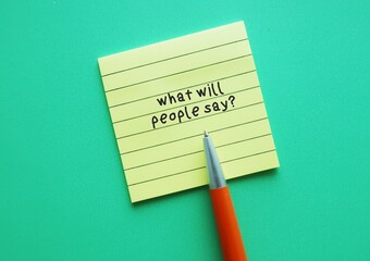 Yellow note on green background with handwriting text WHAT WILL PEOPLE SAY?, caring too much what...