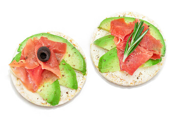 Rice Cake Sandwich with Avocado, Jamon, Olives and Rosemary - Isolated on White. Easy Breakfast....