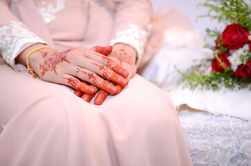 Obraz na płótnie Canvas Henna Tattoo on Bride's Hand. Malay wedding preparation henna party. Temperate white mehndi.