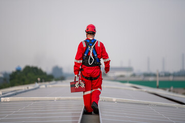 Engineers walking on roof inspect and check solar cell panel by hold equipment box and radio...