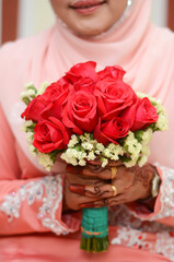 Bride holding bouquet of flowers. Islamic wedding bouquet in bride's hand.
