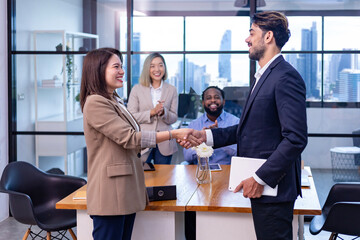 Caucasian business team leader congratulate his teammate employee for the outstanding achievement team performance by shaking hand in the modern office workplace with skyscraper view