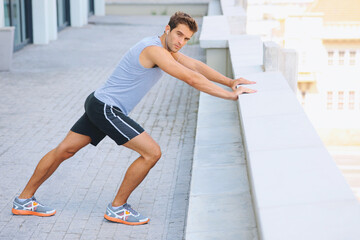 Man, portrait and stretching body on balcony in city for fitness, workout or outdoor exercise. Active male person in warm up, stretch or preparation for training or run in health and wellness outside