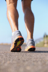 Man, shoes and legs running on road for fitness, workout or outdoor exercise on asphalt. Closeup of male person or athlete on street with sneakers for run, cardio or floor grip in health and wellness
