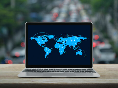 Connection line with global world map on laptop computer monitor screen on table over blur of rush hour with cars and road, Business communication online, Elements of this image furnished by NASA