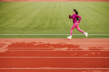 Obraz premium A fit sportswoman running on stadium.