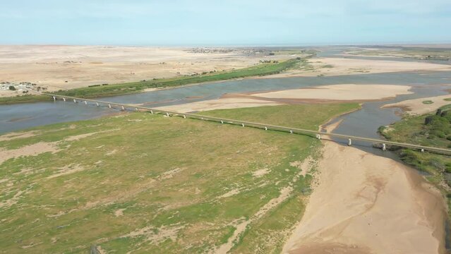 Pull back reveal Ernest Oppenheimer Bridge across the sandy Orange River flood plain