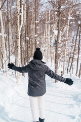 happy Traveler with Sweater walking on snow covered forest in frosty weather. Winter Travel, Adventure, Exploring and Vacation concept