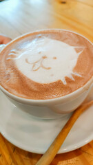 A cup of hot chocolate decorated in the shape of a cute cat