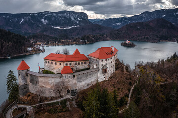 Lake Bled, Slovenia - Aerial view of beautiful Bled Castle (Blejski Grad) with Lake Bled (Blejsko Jezero), the Church of the Assumption of Maria and Julian Alps at background on a cloudy winter day