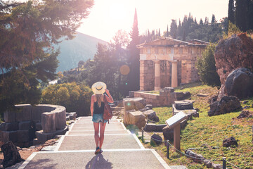 Woman tourist in Greece, Delphi touristic site at sunset