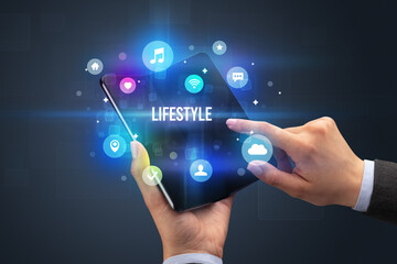 Naklejka premium Businessman holding a foldable smartphone