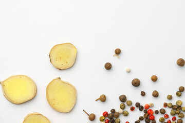 Ginger slices and pepper spice on white background