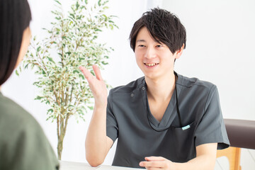 笑顔で問診するドクター　Doctor interviewing