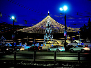 Christmas tree with a luminous illuminating at night on the square