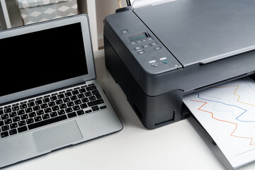 New modern printer and laptop in the office on table