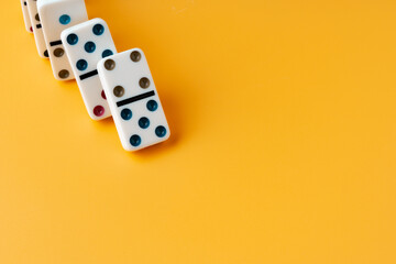 Row of domino tiles on yellow studio background