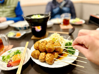 飲み会でつくねを取る手元 © smile