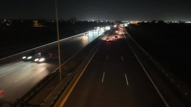 Expressway at night illuminated by the bokeh of car lights, captured in a time-lapse